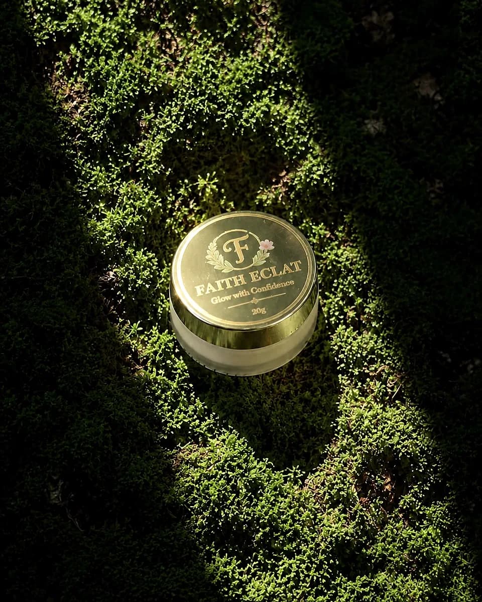 Faith Éclat Glow Cream jar lit dramatically on a bed of moss